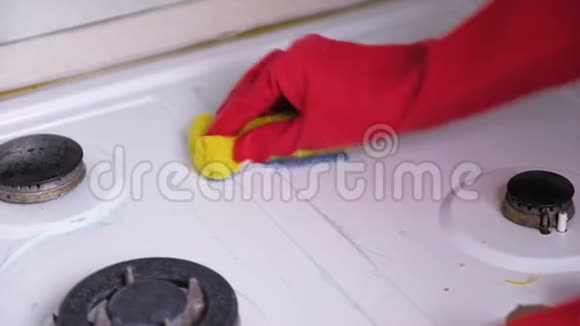 女人双手戴着红色橡胶手套用刷子和海绵清洗脏煤气炉视频的预览图