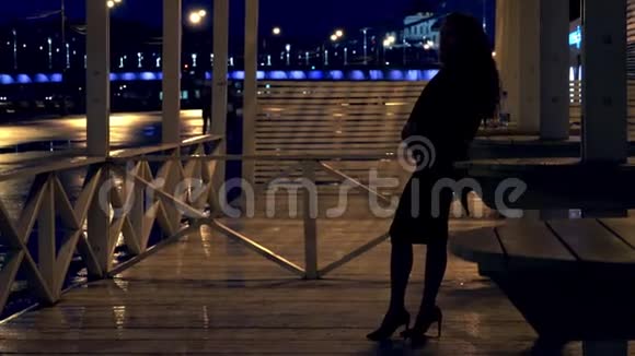 晚上站在莫斯科公园露台上的年轻浪漫女子视频的预览图