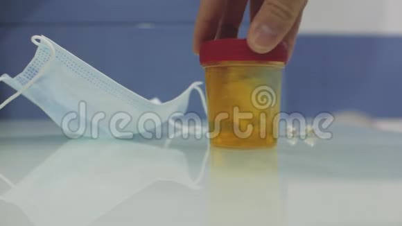 男性实验室技术人员将尿样混合在尿液容器中的桌子上视频的预览图