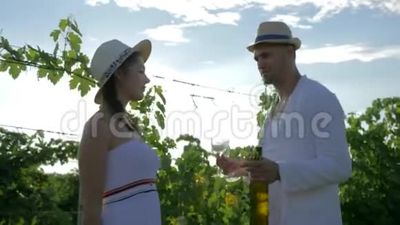 快乐的农夫用秋收的酒招待农村姑娘在阳光明媚的葡萄园里调情视频的预览图