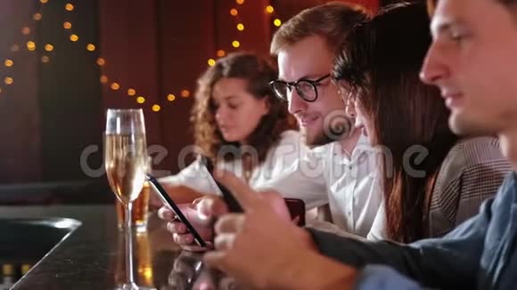 朋友男人女人休闲友谊和技术概念在酒吧或酒吧喝啤酒的智能手机朋友视频的预览图