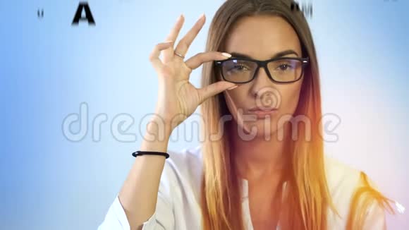 一个漂亮的女孩戴眼镜检查眼科医生的视力视频的预览图