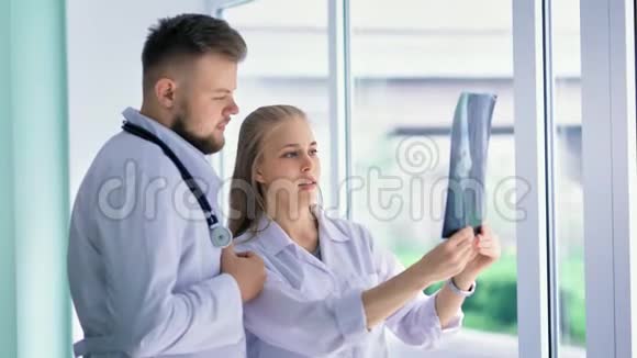 穿着白大褂的男女医生用X光透视快照视频的预览图