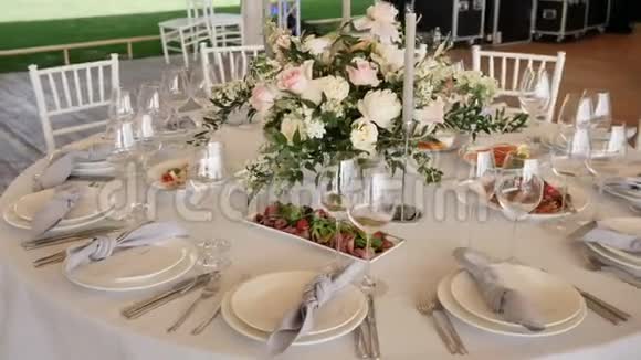 宴会有大桌子和白色桌布各种美味的菜肴花安排蜡烛装饰视频的预览图
