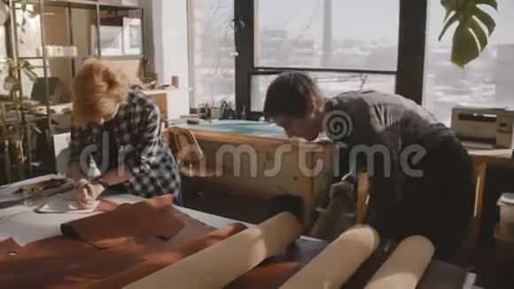 小工艺工匠业务合作伙伴在一个车间合作手工皮具生产过程视频的预览图