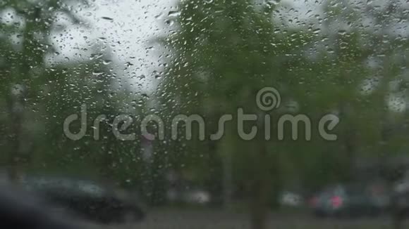 飓风和冰雹期间多雨多风的天气从温暖的汽车透过雨滴的挡风玻璃观看视频的预览图