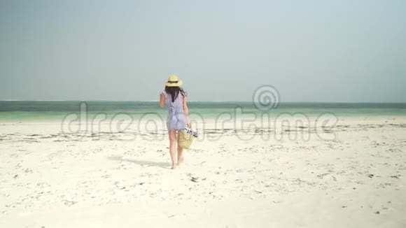 年轻女子光着脚在海滩上朝大海走去视频的预览图