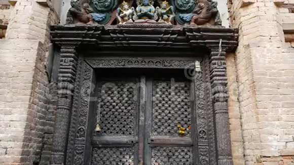 观赏设计寺庙入口从下面的老入口在门口上方有五颜六色的木制古神雕塑视频的预览图