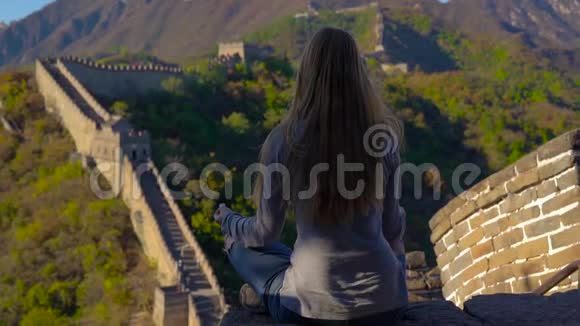 一位年轻女子坐在中国长城上沉思的慢镜头塔拉维尔的中国概念视频的预览图