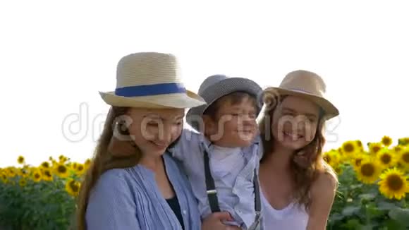 戴着草帽的快乐兄弟姐妹一起在黄色的向日葵田玩得开心的肖像视频的预览图