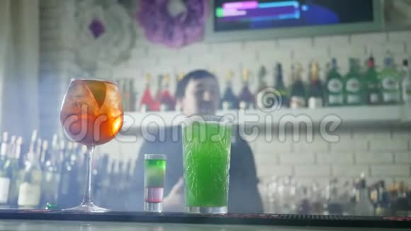 彩色鸡尾酒新鲜浆果近距离站立在吧台上背景为酒保表演杂耍视频的预览图