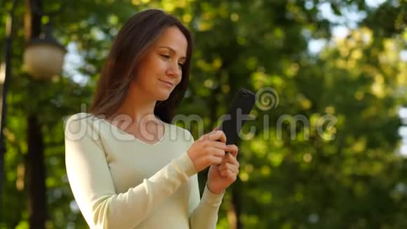 女人喜欢使用智能手机从手机屏幕上阅读视频的预览图