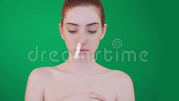 年轻的红头发女人用吸入棒堵住了鼻子视频的预览图