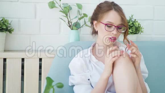 漂亮的模特在卧室背景上用化妆霜治疗她的腿视频的预览图