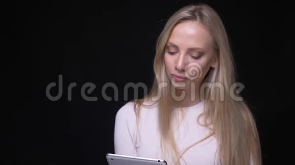 年轻漂亮的金发女性使用平板电脑的特写肖像并显示绿色的彩色屏幕用相机看镜头视频的预览图