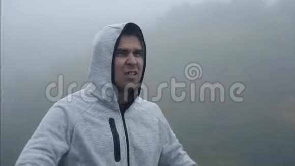 一个沮丧的人站在雾中闭着眼睛尖叫视频的预览图