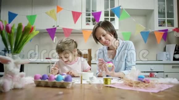 母女俩坐在餐桌旁一起用彩蛋做窝一起在厨房里嬉戏视频的预览图