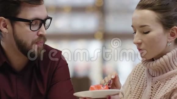 成年女人正在给她的男人喂蛋糕然后自己在咖啡馆里吃视频的预览图