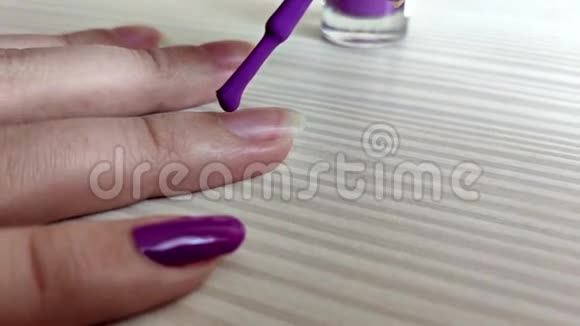 女人用紫色指甲油涂指甲视频的预览图