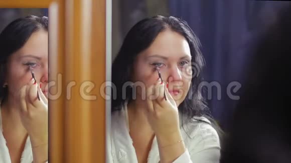 镜前的一位年轻女子用刷子涂抹眼影视频的预览图