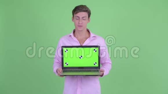 穿着紧身的年轻商人展示笔记本电脑视频的预览图