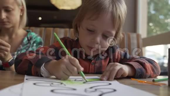 孩子们用蜡笔在咖啡馆的一张纸上画画学前教育视频的预览图
