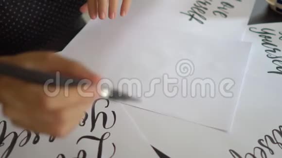 一位年轻女子用刻字技巧在纸上书写书法的特写镜头她写的是爱自己视频的预览图