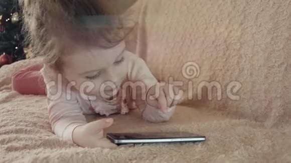 小女孩在家玩智能手机视频的预览图