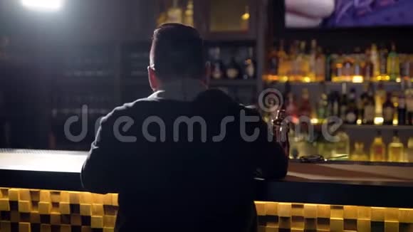 给那个人喝一杯一个在酒吧喝威士忌的男人的特写镜头视频的预览图