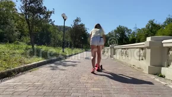 公园里有滑板车的年轻女人视频的预览图