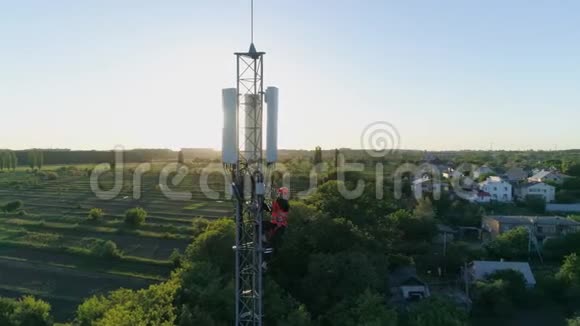 维修工人利用日落背景下的安全设备对通信塔进行高水平维修视频的预览图
