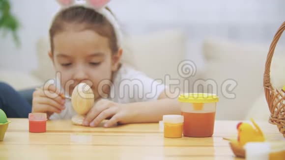 创意女孩选择了绿色来画画可爱的女孩正在复活节彩蛋上画一个绿色的微笑复活节概念桌子视频的预览图