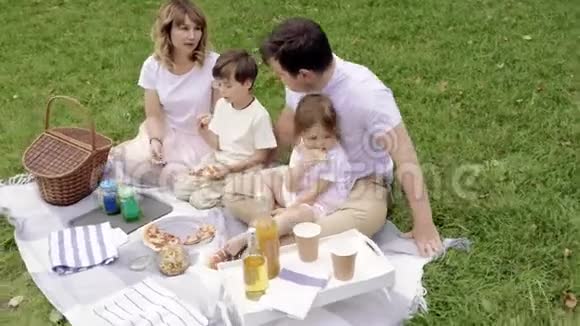 快乐的一家人吃比萨饼在野餐中玩得开心视频的预览图