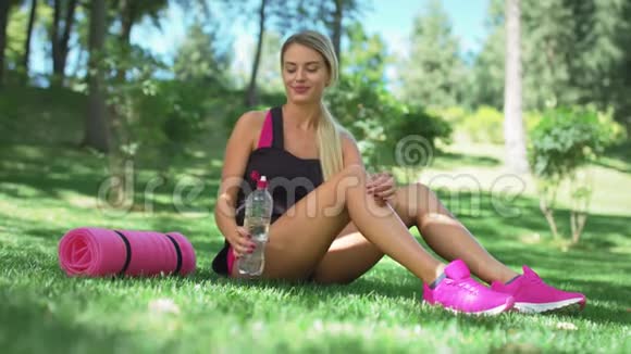 运动女子夏季公园健身瓶中的饮用水视频的预览图