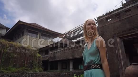 慢镜头年轻女子游客参观贝都古尔废弃而神秘的酒店印度尼西亚巴厘岛巴厘视频的预览图