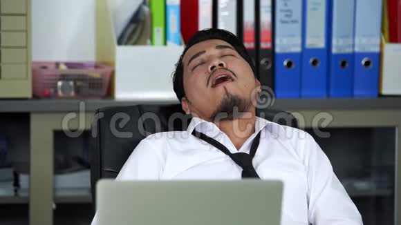 商务人士在工作桌上睡觉时使用笔记本电脑视频的预览图