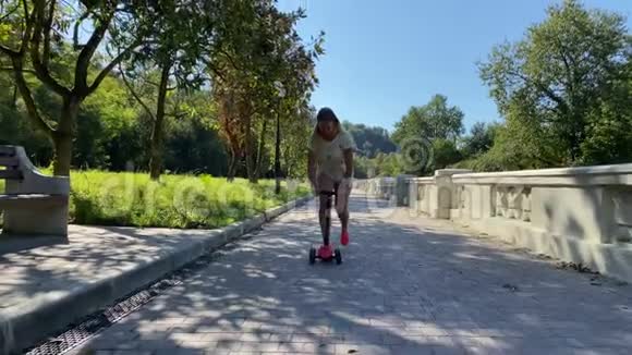 公园里有滑板车的年轻女人视频的预览图