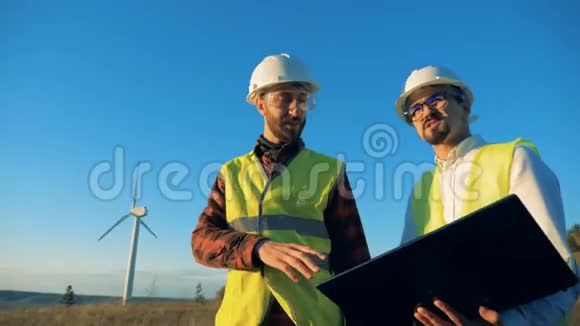 阳光明媚的风景有两位专家在风车上穿行视频的预览图