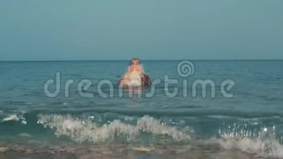 在海水中跳跃的年轻女孩在海里游泳的青少年视频的预览图