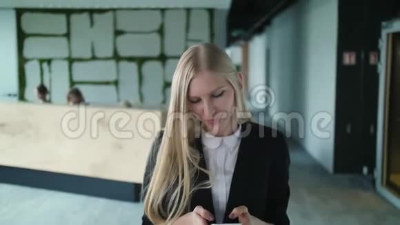 办公室里热情的女人用手挥手一位身穿夹克衫手挽着手向匿名者致意的优雅年轻女子视频的预览图