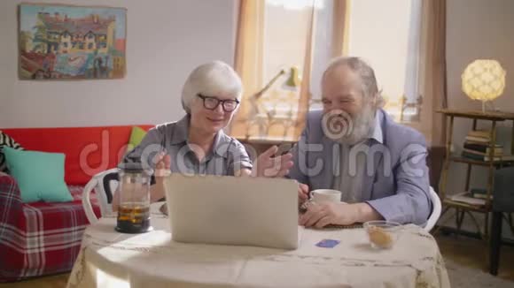 一对老夫妇漂亮的祖母和时髦的胡子爷爷在视频中交谈视频的预览图