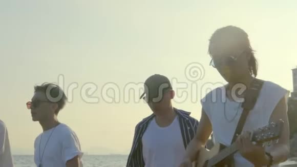 亚洲年轻人在沙滩上散步唱歌视频的预览图