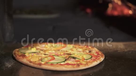 从砖烤箱里拿出一盘准备好的蔬菜披萨视频的预览图