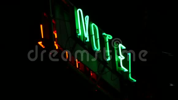 复古汽车旅馆标志红色和绿色霓虹灯在夜间照明的道路上视频的预览图