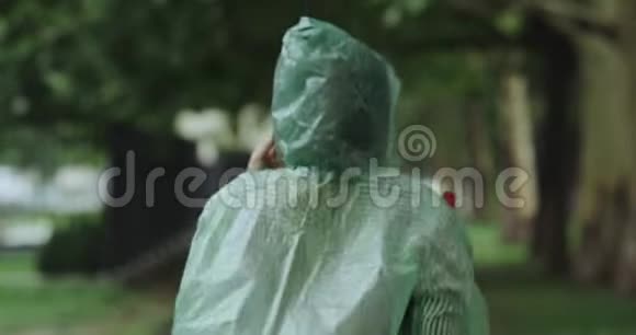 雨天跑女人穿过教区穿着绿色雨背心4k视频的预览图