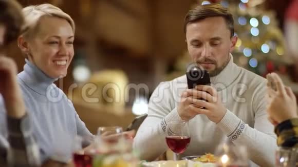 带着智能手机的无聊圣诞晚餐亲密的情侣视频的预览图
