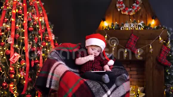 圣诞装饰品上玩智能手机的小男孩视频的预览图