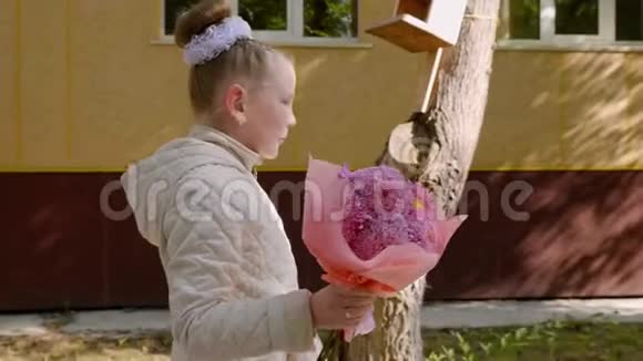 可爱的女孩带着鲜花回学校侧视慢动作视频的预览图