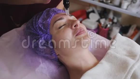 特写美容师用特殊的仪器在病人脸上做水皮和清洁保湿视频的预览图