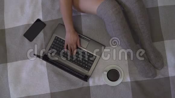 头顶射中年轻的商业女孩在家里坐在床上用笔记本电脑和手机工作4K视频的预览图